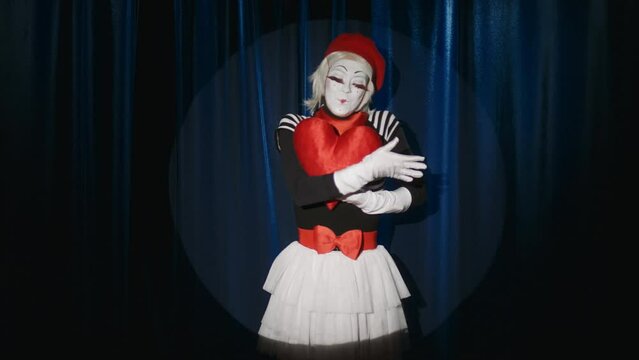 Female mime artist appearing on stage with heart toy and showing improv comedy performance on camera