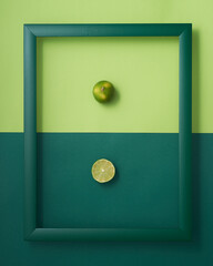 Lime in wooden picture frame on two-tone green background