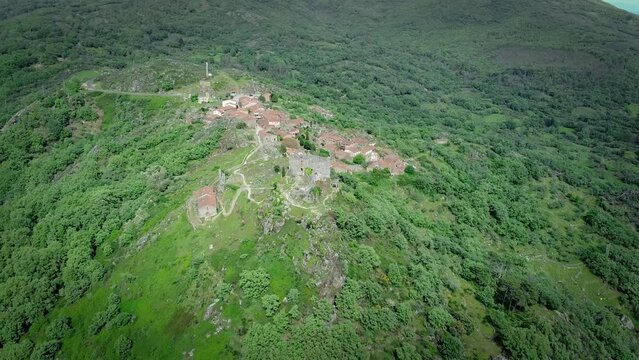 Castelo e aldeia sob um monte verde