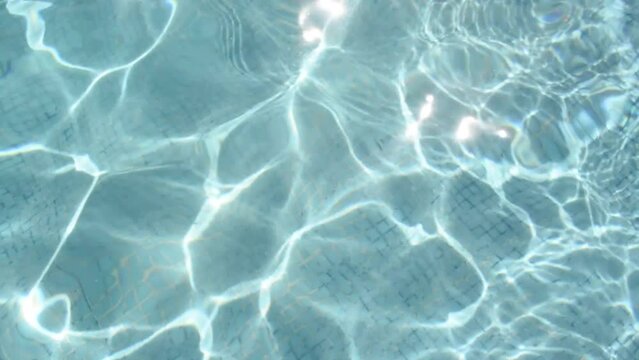 Fondo del reflejo del sol en el agua de una piscina ideal para texturas acuáticas vacacionales