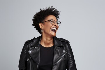 Obraz premium Portrait of a happy afro-american woman in her 40s sporting a classic leather jacket on white background