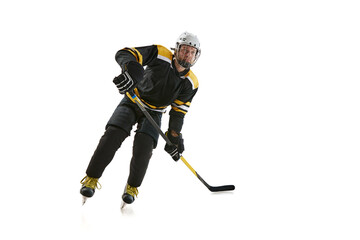 Naklejka premium Competitive young man, hockey player in black uniform training, playing isolated on white background. Concept of professional sport, competition, game, tournament, active lifestyle