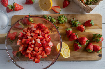 Marinated and  chopped strawberries in a glass bowl on kitchen counter