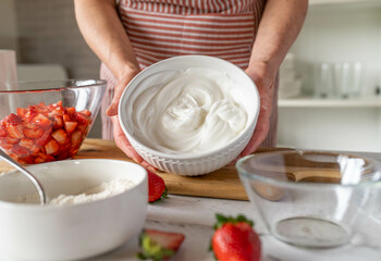 Bowl with fresh whipped egg white holding by woman´s hand
