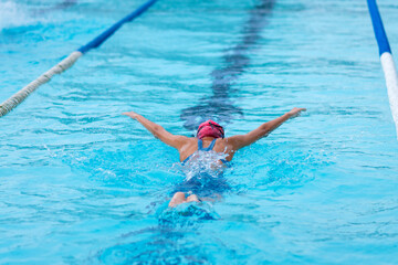 young girl athlete swimmer swims at competitions butterfly. Water sports and competition, learning to swim classes for children - 786403722