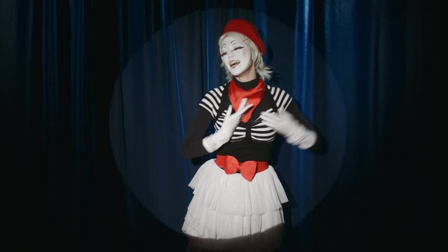 Funny female mime artist bowing in front of audience, blowing kisses and showing hand heart, then leaving stage after comedy performance