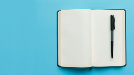 Open notebook with blank pages and pen on light blue background