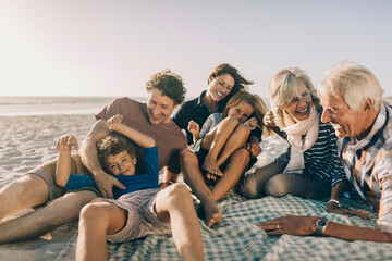 Multi-generational family laughing together on beach