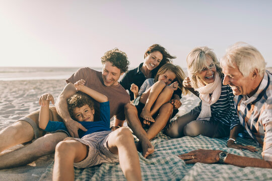 Multi-generational family laughing together on beach