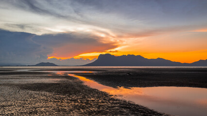 Sunset on the beach in Bako National Park, Borneo, Malaysia, Fiery colors of the sky, low tide of the sea and view of Mount Santubong - 786414534