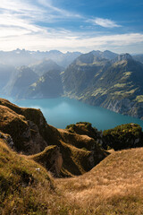 Fototapeta na wymiar Lake in a valley seen from Fronalpstock summit in Switzerland. Swiss Alps iconic view