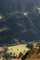 View of a valley in Swiss Alps. Bright sunny day with low clouds in Switzerland