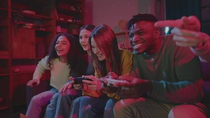 Cheerful company of friends playing video games in room