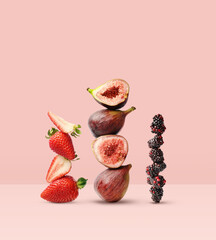 Creative layout made of strawberry, figs and blackberry on the pink background. Food concept. Macro concept.