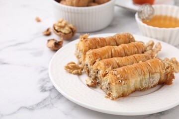 Eastern sweets. Pieces of tasty baklava on white marble table, closeup. Space for text