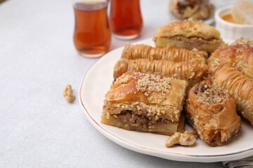 Eastern sweets. Pieces of tasty baklava on white table, closeup. Space for text