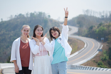 Group of asian female travellers standing by the rural road, like number 3, on high mountain during summer travelling vacation, soft focus, asian travel lifestyle concept.