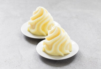 Lemon ice cream in the form of French Chantilly cream. On a plate. Close-up