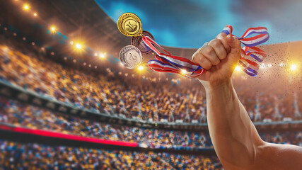 Different medals in hand isolated on big stadium arena - victory concept.