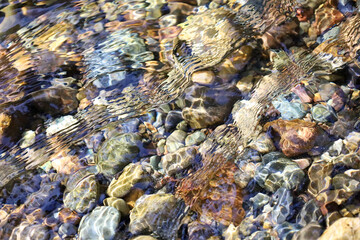 clear water flowing over rocks in a shallow stream of water