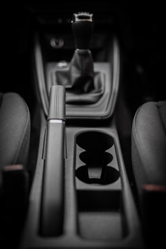 Modern interior of car. black and white. Handbrake, gear stick, cup holders, dashboard 