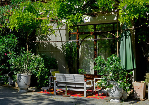 kącik wypoczynkowy na patio przed domem, meble ogrodowe na tarasie przed domem, biała drewniana ławka i donice w kąciku wypoczynkowym, sitting area in the garden, Recreation area	
