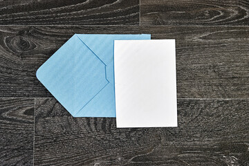blue envelope with Blank paper on wood - White paper sheet on a dark wooden texture 