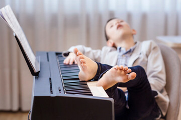 Piano Lessons. Tired Child Boy fell asleep Sleeping during Boring Piano Lessons. Learning Music...
