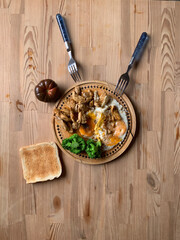 Old cracked wooden round board with lunch on an old kitchen wooden table. Scrambled eggs, broccoli...