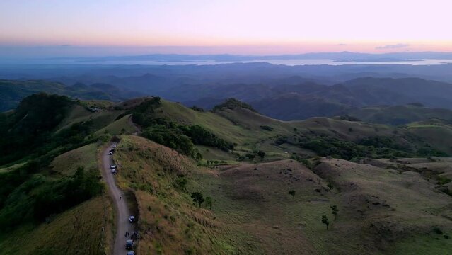 Aerial at sunset in Cerro Pinocho revealing road and mountain in Monteverde Puntarenas in Costa Rica