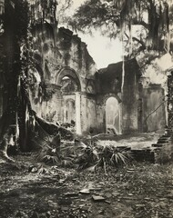 Outdoor black and white vintage photo of the ruins of a grand building overgrown with vegetation and surrounded by trees. From the series "Quest.”