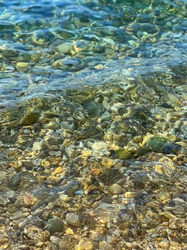 Sea pebbles stones in transparent water.