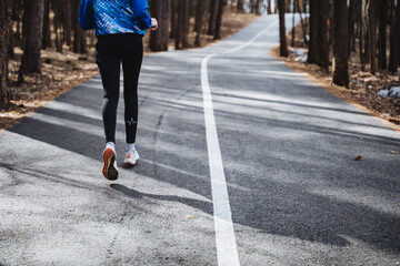 A person is rolling down an asphalt road in the woods for recreational sports