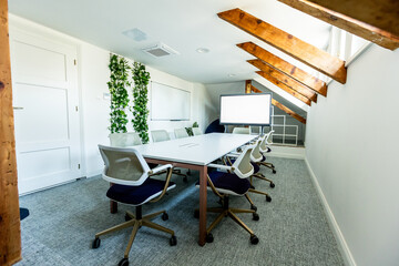 Modern cozy conference room with wooden beams and greenery awaits a creative meeting at dawn