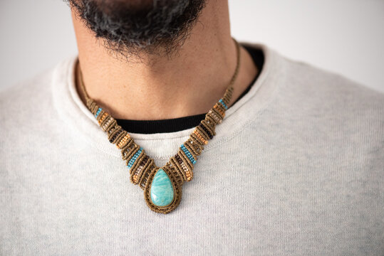 unrecognisable men's collar detail with handmade macrame necklace in browns with a light blue aquamarine stone. gift for father's day