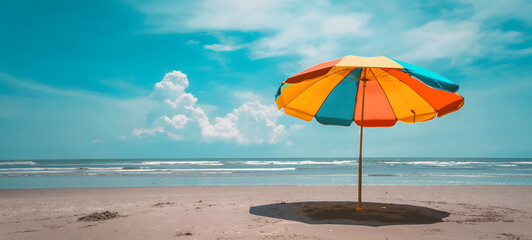 Fototapeta na wymiar Serene Beach Day with Vibrant Orange and Red Parasol under Sunny Blue Skies