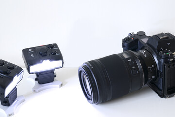 Image of a mirrorless interchangeable lens camera system and wirelessly controlled remote flash gun