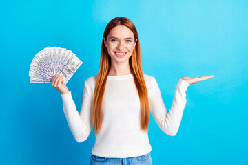 Photo portrait of attractive young woman hold money fan empty space dressed stylish white clothes isolated on blue color background
