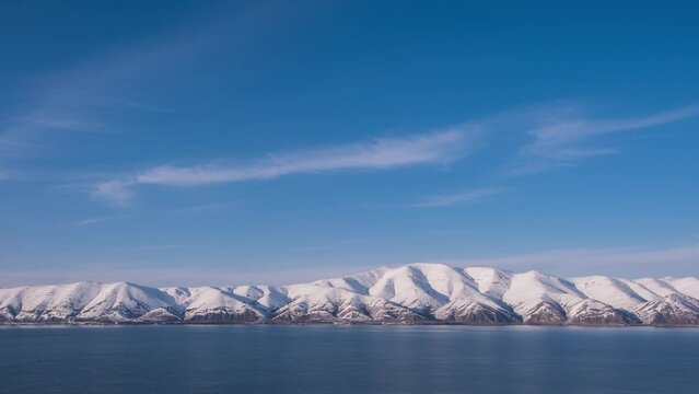 mountain range on the lake shore covered with snow, Sevan, timelapse, 4k