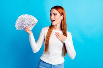 Photo portrait of attractive young woman hold money fan touch chest amazed dressed stylish white clothes isolated on blue color background