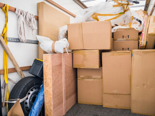 A removal van and cardboard boxes and packing materials. Concept for moving home, packaging,...