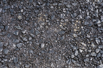 Świeżo zagęszczona pierwsza warstwa asfaltu. Wylewanie podstawowej pierwszej warstwy asfaltu na budowie nowej drogi. - obrazy, fototapety, plakaty