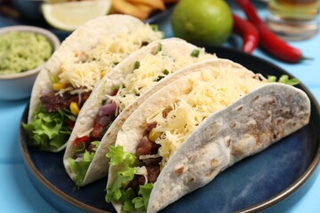Delicious tacos with meat and vegetables on table, closeup