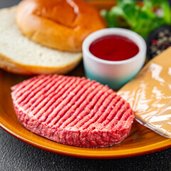 burger set raw cutlet, bun, cheese, tomato sauce, greens fresh cooking appetizer meal food snack on the table copy space food background rustic