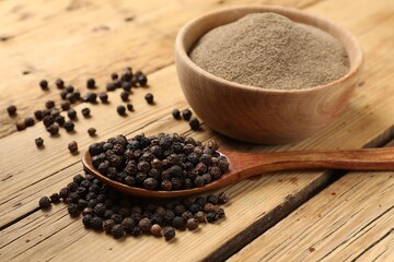 Aromatic spice. Ground and whole black pepper on wooden table, closeup