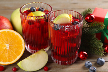 Aromatic Sangria drink in glasses, ingredients and Christmas decor on table