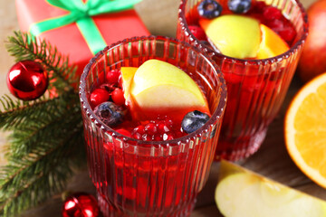 Aromatic Christmas Sangria drink in glasses on table, closeup