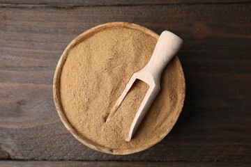 Dietary fiber. Psyllium husk powder in bowl and scoop on wooden table, top view
