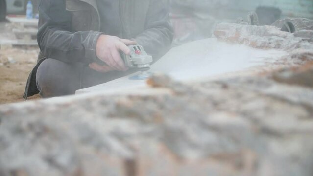 Close-up of male hands grinding a stone. A man creating a stone sculpture.
