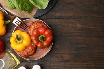 Delicious stuffed bell peppers served on wooden table, flat lay. Space for text